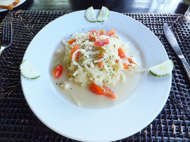 まずは前菜のキューカンバ・サラダ。<br />ま、名前の通りキュウリのサラダですね。<br />ただ、東南アジアのキュウリらしいというか、<br />なんか日本のキュウリと違って大味なんだよね。<br /><br />そこに、ピーナツらしきナッツ類を<br />砕いたものが混ざっていて複雑な食感が楽しめる。<br />これはタイのソムタムなど<br />東南アジアのサラダにはよくありますよね。<br />気に入ってます。<br /><br />ドレッシングも油っこくなくてさっぱり。<br />ほんのり魚醤の風味が感じられるかな？<br /><br />ま、とにかく、うまい！<br />ってことですね（笑）