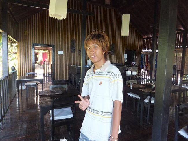 それはそうと、注文をする前に<br />今日は、いままでお世話になった<br />このレストランの給仕をしている<br />ウイン・テュウくんに写真を撮らせてもらった。<br />最終日の、それも<br />ランチタイムを多少フライングして<br />忙しくなる前に。<br />なので、お仕着せの民族衣装ではなくて<br />普段着なんだけどね、<br />でも、下はやっぱりロンジーはいてましたけど。<br /><br />給仕の中で英語が話せるのは彼だけなので<br />彼はいつも忙しそうにしている。<br />でも、笑顔を絶やすことなく、<br />主人の突然のミャンマー語攻撃にも<br />やさしく応対してくれた。<br />