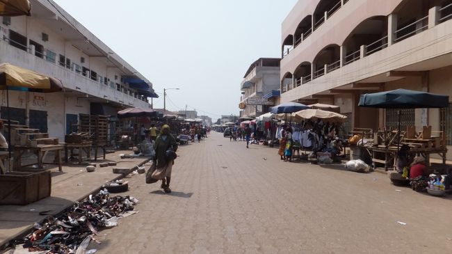 こちらは上の写真よりかはまし。<br /><br />この辺りからバイクタクシーに乗ってMarche des Feticheursに向かいます。<br /><br />荒い運転されるのは嫌なので強面ではない小柄なおじさんのバイクタクシーを捕まえたつもりが、かなり運転が荒かった。途中で信号で停まる際に停まりきれずに少し滑って別のバイクタクシーと軽く衝突。振り落とされはしなかったが恐かった。<br /><br />周りの人達はゲラゲラ笑っていたが、運転手のおじさんはかなり機嫌悪そうになる。しばらくは安全運転してくれたがまたすぐにスピードを上げる。早く目的地に着いてくれないか、気が気でなかった。<br /><br />料金は1000CFA（約160円）で乗りました。lonely planetには500CFAと書かれていましたが。