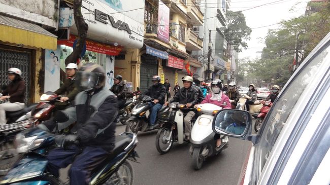 ハノイの朝の通勤時間帯の道路をタクシーから撮りました。両方向とも道路一杯に広がって走ってますが、何となく脇に寄って行き交う技はスゴイ！ワタシには到底真似できません。