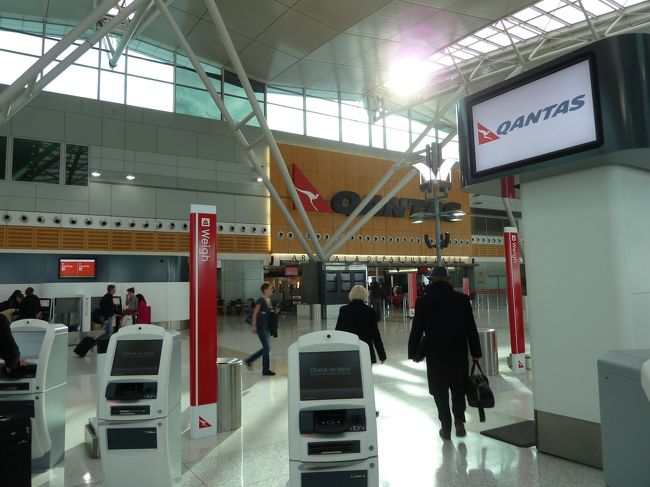 ターミナルに入ると、そこはカンタス、カンタス、カンタス。さすがシドニー空港、カンタスの本拠地ですね。<br /><br />カンタス国内線の乗り方は一応事前にホームページで予習したつもりですが、やはり迷いました。自動チェックイン機にバーコードをかざす穴があるのですが、プリントアウトして持参した紙をそこにかざし、預ける荷物の有無などを画面で選択した記憶があります。<br /><br />荷物を預ける際はそのチケットも出てくるのですが、息子と荷物のチケットを取り忘れるプチ・ハプニング。たまたまカンタスの係員がチケットを回収してくれていたので、無事手元に戻ってきました。<br /><br />写真左奥に荷物を預ける場所がわかりますでしょうか？荷物のチケットを持ってそこで荷物も自動チェックイン。人件費を抑えていますねぇ〜。