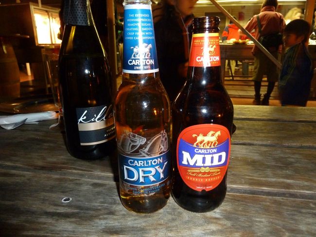 そして、この一連の旅行記の中でも取り上げ続けているOZビール。今回もまた初めての種類をいただきました。ちなみに、左奥のボトルがエアーズ・ロックのサンセット観賞をする際に登場したスパークリング・ワインです。<br /><br />ちょっとした情報を。BBQのカウンターと酒屋が合体しているようなこのレストランですが、アルコールを購入する際は持ち帰り用かその場で飲む用かを聞かれます。持ち帰り用の場合、そこで飲むことは許されません。私はスパークリング･ワインを持ち帰り用で購入したので、夕食時に持参したもののグラスを貸していただけず、飲まないまま部屋へ持ち帰りました。また、購入の際にルーム・キーの提示を求められるのでご注意ください。