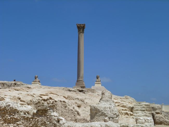 ＜ポンペイの柱＞<br />3世紀ごろにローマのディオクレティアヌス帝が建てたとも、391年にキリスト教徒によって破壊されたセラピス神殿の円柱とも言われている。手前の1対のスフィンクスは新王朝時代のもの。