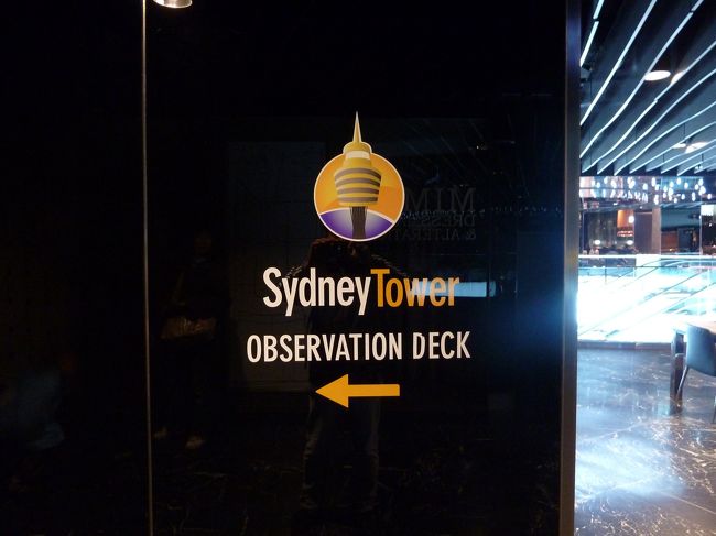 最後の晩は、シドニー水族館とセットでチケットを購入していたシドニー・タワーに登ります。<br /><br />ところが、あいにくの雨・・・。と言っても、シドニーの雨は瞬間的に降るのみだそうで、シドニーの人は雨でも傘を持ち歩かないとか。<br /><br />だから、ではないですが、我が家も傘を持たずに屋根のあるところを渡り歩き、シドニー・タワーまで移動。本来なら天候の良い日に登りたいところですが、今日登らないともう機会がないので前に進むのみです。<br /><br />ウエスト・フィールド・ショッピング・センターまでたどり着いたものの、タワーの展望台入口がなかなかわからず苦労しました。5階にあります。<br /><br />入口ですが、空港の保安検査場のような手荷物検査と金属探知機がありました。私が行ったときは団体客が前にいたので、登るまでに時間が掛かりました。