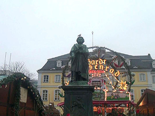 ボン　ベートーベン像<br />セントゴアールハウゼンで昼食を済ませ、旧西ドイツの首都であったボンへ。ここは比較的新しいビルが並んでいます。百貨店もあり、新しい建物と古い建物が混在しています。まだ、明るかったのですがクリスマスマーケットを見学することができました。市庁舎はクリスマスのデコレーションになっています。そしてベートーベンが住んでいたという家へ。近くのビルの壁にはベートーベンの似顔絵も描いてありました。<br />