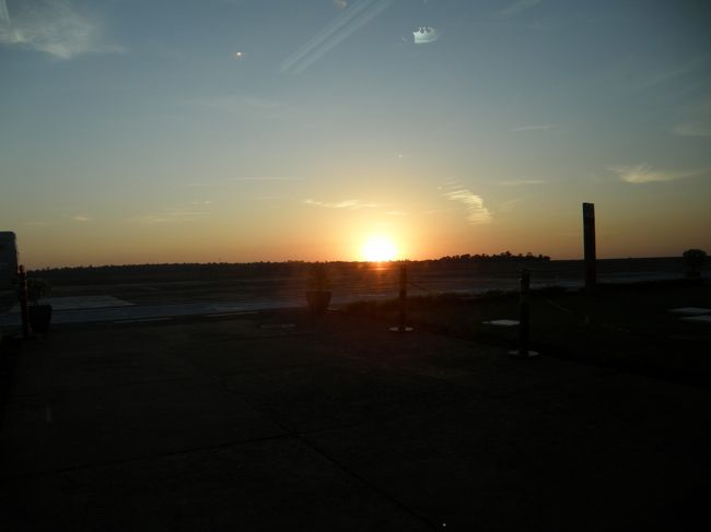 ご飯を食べた後はツアー仲間のＭさん、Ｓさん、Ｏさんとおしゃべりしてました。この時、Ｏさんが「実はブラジリアも行きたかったん ですよね～」と。現代建築に興味があって、見たい教会があるんだそうで。とは言え、乗継時間は1時間しかないし「空港までは行くけど 見れなくて残念だね」という話をしてたんですが、まさかまさか。後であんな事になるとはこの時は全く思ってなかったんですよね。 そんな話をしていて、気が付いたらもう7:00。あれ？6:45、搭乗開始じゃなかったっけ？まあ、とは言え海外では遅れる事はよくあるものね。仕方がないかと、待ってるうちに 日の出を迎えちゃいました。 <br /><br />そのあとも、ひたすらずーっとしゃべってましたが、待てども待てども出発の気配なし・・・。「どうしたのかな？」と思ったら 経由地のクリチバの天候が悪くて、空港がクローズしてるんだって。あらららら・・・。よくある事だから仕方ないけど、 乗り継ぎに間に合うのかな？と思ったら、案の定このままでは間に合わないって事で、添乗員Ｋさんからブラジリア12:00発の便から 21:08発の便に変更しますとの事。まあ、仕方がないよねぇ。ブラジルだし。