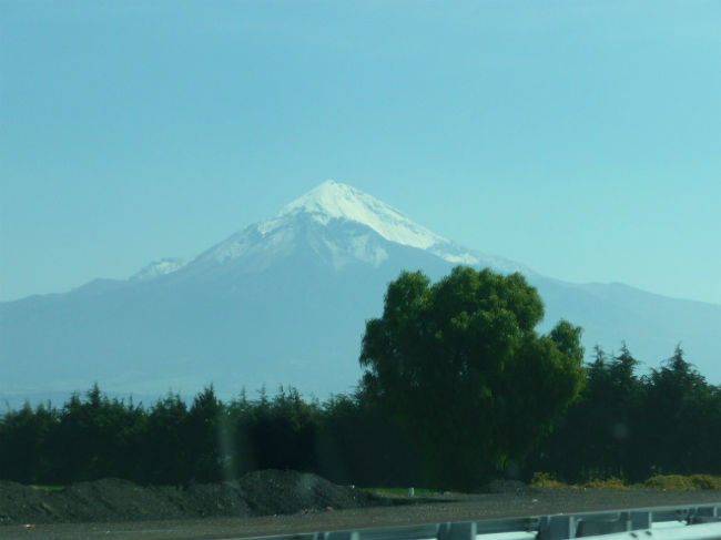 プエブラを過ぎて暫くするとメキシコ最高峰のオリザバ山（5699m）がドーンと見えてきます。<br />山の形が美しく、メキシコに永住している日本人の友人が趣味か副業?の山岳ガイドで時々登るそうですが、とても険しそうな山景です。<br />