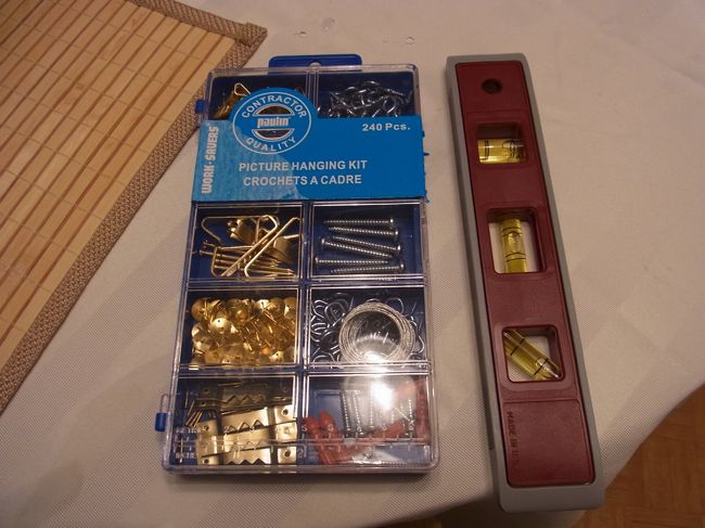 夜、友人が額を掛けるお手伝いしました。<br />これ、、、、必需品なんだ〜！<br />掛け金具などの一揃いと、水準器まで！<br />釘などが金色というのが、日本とは違うな。<br /><br />日本なら銀色だと思う。<br />しかし、これ本当に文化の違いですね。<br />壁に額かける基本的習慣がない。<br />床の間に掛け軸、柱に一輪挿し、門に表札くらいなものかも。<br />最近は額も掛けはするけれど、一般的には<br />まだ習慣にまでなっていない。<br />掛けるバランス慣れていなくて、下手だしね。<br />勉強になりました。<br /><br />