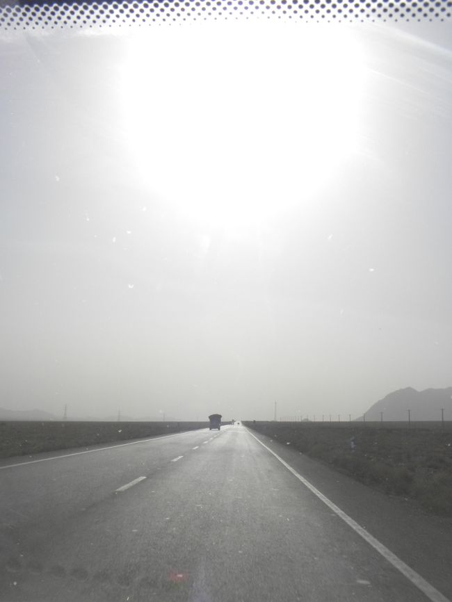 茶色い大地の中、まっすぐな道路が整備されています。