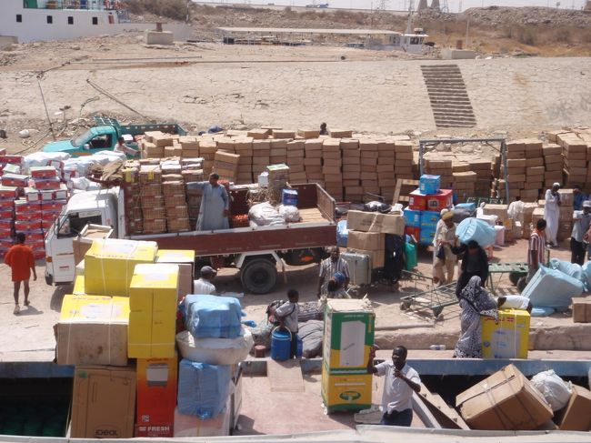 デッキにも荷物が置かれ、その間に人間が寝ている。もっとマシな船はないのか！<br />