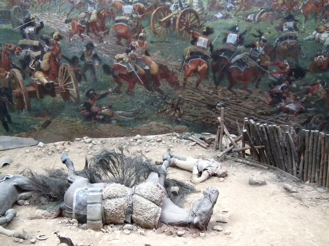 　これがそのパノラマ館の中です。後ろは円形の壁に描かれた絵です。で、この手前の倒れた馬は造作です。で、戦場の音声が流れ、馬のいななきなんぞが大砲の音に混じって、ブルルル、ドォ〜ンって。なんなの、これ？