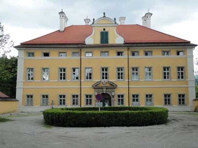 フローンブルク宮殿<br /><br />ヘルブルン宮殿をあとに次に向かうのはフローンブルク宮殿。ここはトラップ家の正面のロケ現場。バスをKleingmainで降り、さっきバスから見えたところを目指して１０分くらい歩いて行くとありました。やはりここがそうでした。マリアがギターと荷持を抱えて歩いてきた道も目の前です。Private onlyの張り紙があり、今はモーツアルトテウムの寮になっています。、カメラも備え付けてあるので中には入れません。門の前をうろうろしながら写真を撮っていると自転車の一団がやってきました。Bike tourと書かれているのでどうやらガイドツアーのようです。しばらくにぎやかな時間が過ぎ、またあっという間に静寂の時間が戻ってきました。目の前にはウンテンベルクがきれいに見えます。あーーー！雲もなくきれいに晴れている。行く順番を間違えたな、と後悔しても後の祭りでした。