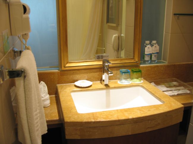 掃除の行き届いた洗面台に、白くてフカフカのタオル達。。。<br /><br />鏡の右に、”免費”(無料ってことですね)の水二本発見