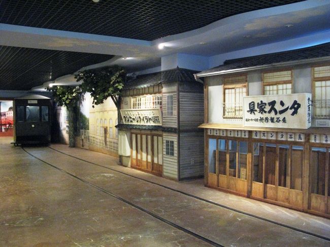 釜山という名前の由来は、<br />釜をひっくり返したような山々の地形から来ているそうです。<br /><br />このあたりはもともと東菜（トンネ）という内陸部に<br />中心地があったそうですが、<br />1867年の日朝修好条規（不平等条約）により、<br />日本に対して、朝鮮は開港することになった。<br />その１つがこの釜山で、<br />以降、港周辺には日本人街が形成されていきます。<br /><br />さらに植民地化後は、港湾整備がなされ、<br />海沿いに主要官庁や商業施設等が建設され、<br />瞬く間に中心地が移動してしまったそうです。<br /><br />ここでは、<br />日帝植民地時代の釜山中心部の街並みを再現しています。<br /><br />