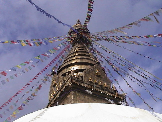 頂上には、仏塔。<br /><br />ボダナートと同じく、<br />仏塔には“ブッダの目”が描かれている。<br /><br />参考までに、<br />仏塔の先っぽから八方に広がっているのは、<br />旗のようなもの。<br /><br />この旗にはお経が書いてあって、<br />１回なびけば、<br />１回お経を読んだことになる。<br /><br />どんどん横着になってるやろ？<br /><br />