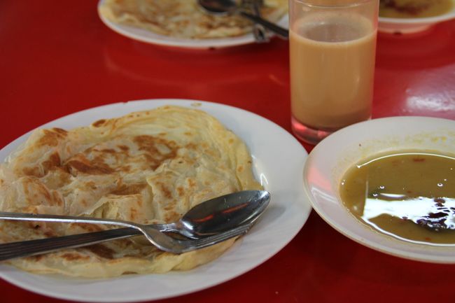 お待ちかねのロティ・チャナイです。<br /><br />前の写真のように生地を一度大きく引き伸ばして折りたたむので、平らなクロワッサンのような感じで激うま！<br />カレースープをつけて食べます。<br />インド料理らしくお茶はチャイです。<br />両方合わせて2RM(60円)安い！