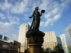 駅前の噴水に立つ如是姫です。この如是姫は、善光寺と関わりが深いということで、善光寺縁起から由来が説明されていました。昔、天竺の毘舎離国にある長者がいて、大変可愛がっていたのが一人娘の如是姫。ところが、ある時、悪い病気にかかりどんな治療をしても治りません。長者は、日頃ケチで、不信心。しかし、娘の命を助けてくれてと涙ながらにお釈迦さまにすがります。お釈迦さまは、西に向かい南無阿弥陀仏と唱えるように諭し、長者が一心に唱えると、阿弥陀さまが現れ、如是姫の病気は回復したというのです。如是姫は善光寺の御本尊である阿弥陀如来様に助けられた人であり、善光寺を向いて香花をささげているのだそうです。 
ここから、バスで戸隠に向かいます。

