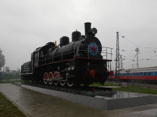 ■2012.7.12　ロシア号5日目<br />　朝、今日もやはり6時30分頃に目が覚めた。寝ている間に雨音に少しだけ気づいていたが、雨はほぼ止んで曇りになっている。バム鉄道（第二シベリア鉄道）の分岐駅であるタイシェトは、もう過ぎてしまっている。<br />　トイレへ行き、身支度を整える。どうでもいいことだが、ズボンの股の部分が破れかかっており、帰国時の飛行機で短パンというわけにもいかないだろうから、これからロシア号車内では寝巻用の短パンでずっと過ごすことにする。<br />　さてそろそろ次の停車駅、と思って資料に目を通すと、タイシェトを過ぎた辺りで時計を1時間戻さねばならないようである。つまり再び5時台に戻ることとなり、仕方ないのでまた横になった。<br />　6時少し前にレショトゥィに少しだけ停車し、その後に定刻の7時05分にイランスカヤに到着した。周囲に特に何もない小さな駅だが、20分も停車するので、駅近くに展示されているSLや駅前にある何やらよくわからない記念碑、野良犬などを撮影して朝の散歩代わりとする。<br /><br />＠こういう展示がいたる駅にある