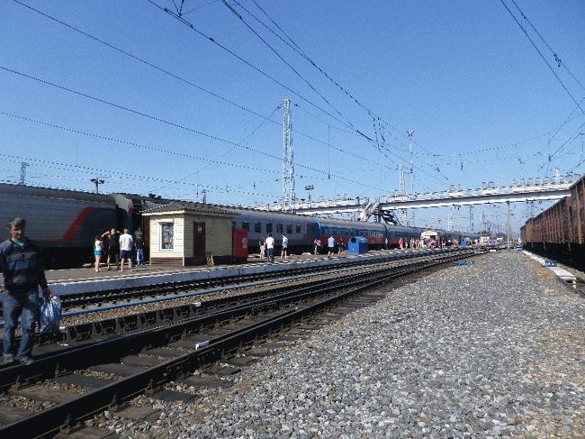 　駅舎に近い商店で夜用のピロシキを買い、ホーム戻って別の売店を物色する。しかし、すぐに指差しで買えそうなものは、やはりピロシキや茹でじゃがいもばかりである。とある売店に手のひらサイズの大きなエビを蒸したものが置いてあったが、この暑さを考え（しかも炎天下に放置状態であった）、さすがに諦めてしまった。<br />　小さな駅での長時間停車となったため、多くの乗客が降りてアイスを買って食べていた。先頭の機関車が付け替えられたので行ってみようとしたが、なんとホームから外れてしまっている。そこまで行っても怒られないかもしれないが、面倒なことになっても意味がないから、こちらも諦めてしまった。<br /><br />＠酷暑