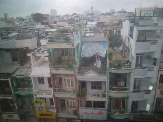 空港に着いたのは夜で、予想どおり蒸し暑い。<br /><br />市の中心部から２kmほど西側に位置するBoss Hotelに宿泊。<br />バスタブはあったものの、クラスとしては2ツ星程度のホテルで、窓の外にあるエアコンの振動が部屋に入ってきてうるさかった。<br /><br />ホテルの窓から街並みを見渡してみると、４階建てほどのカラフルな小さな建物が連担していた。ひとつの建物の間口は４ｍ程度で、下町の匂いが漂っていた。