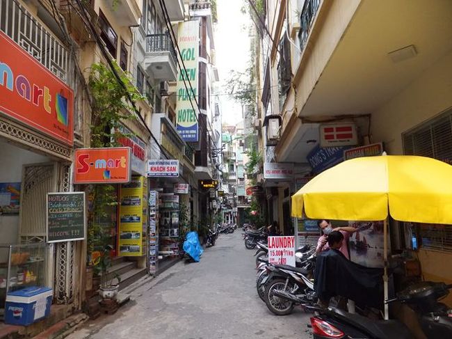 ホテル前の通り<br /><br />　ホテルやお店がぎっしり並んでいます<br /><br /> 黄色いパラソルの向こうには、路上散髪屋さんです。