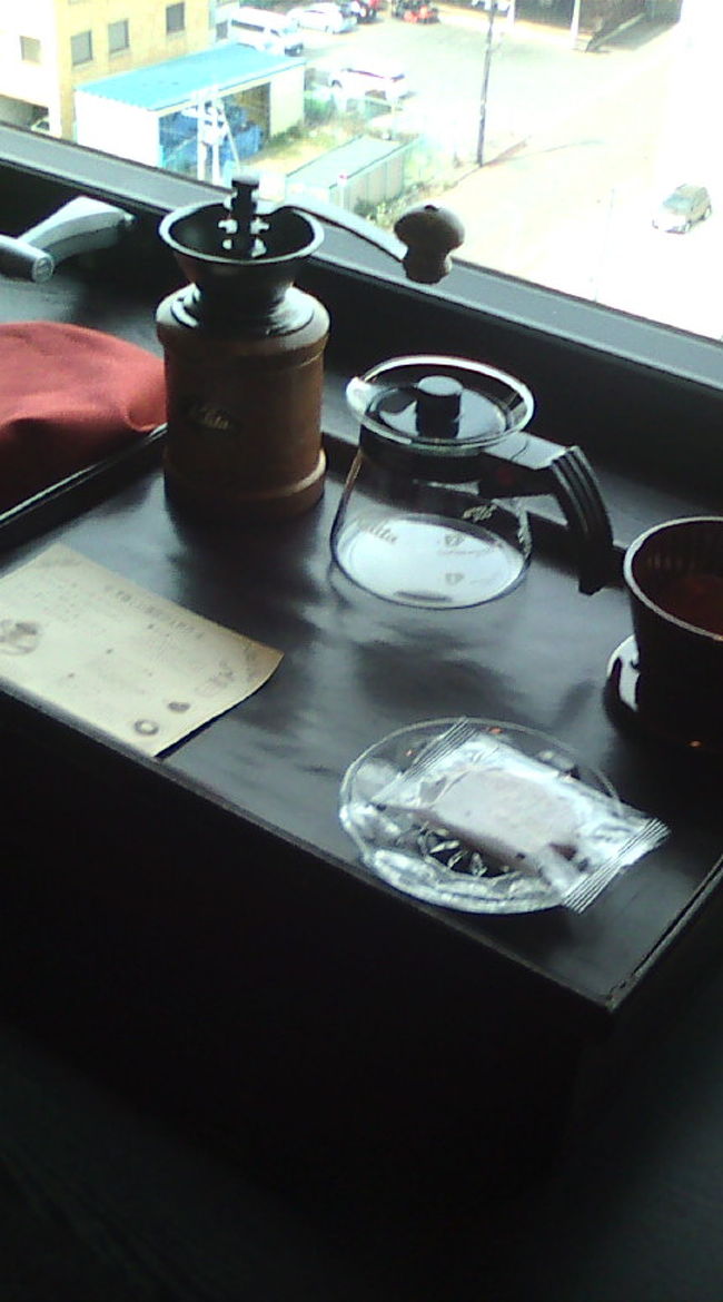 ベットの目の前は大きな窓！窓のところはテーブルになっていて、外を見ながら過ごせるようになっていました。たぶん廊下の反対側の部屋は函館山が見えるんだと思います。<br />そしてテーブルに用意されていたコーヒーセット♪自分でゴリゴリするの楽しそう^^。<br />初め、豆を探してしまいましたが、下の箱にカップと一緒に入っていましたー。