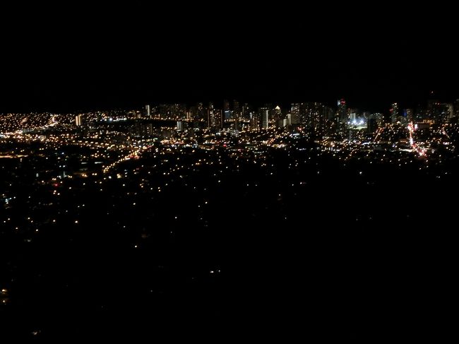 マイクロバスが約束の時間に迎えに来て、いよいよタンタラスの丘です。<br />真っ暗な道をどんどん登っていきます。<br />展望台かと思いきや、夜は道ばたからの見学になるんですね。周りにも車が止まっています。<br /><br />きれいな夜景写真を撮りますよーという写真屋さん（もちろん有料です）がいたりして。<br /><br />バスの脇から夜景を見て写真撮りました。マイカメラです。<br />