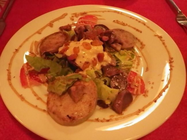 こぢんまりとした店内はほぼ満席。<br />骨董品の台所用品が飾ってあり、テーブルクロスは赤と白（ただしすべて柄が違う）夫婦でやっている感じの素敵な店。<br />地モッティーが多いのかメニューは英語もあるけど奥さんはカタコトです。<br />何とか注文。自家製ハムと砂肝の乗ったサラダ。