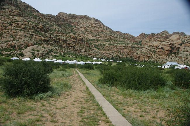 　駐車場から先は徒歩です。徒歩と言ってもゲルまで１〜２分ですがね。宿泊用のゲルが約３０棟ほど，大きく二つのかたまりで設置されています。ゲルの後ろには大きな岩山がそびえています。