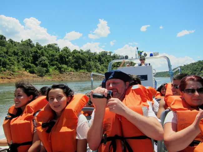 そこで皆さんTシャツやパンツを脱いで、濡れてもいいかっこうでライフジャケットを身につけ、最後の最後はびしょ濡れになるからと、カメラなど貴重品を入れるビニール袋を持ってスピードボートに乗り込みます。かなりのスピードで走るので、振り落とされないように必死です。私たちは舳先に座ることになりました。最初はこのようにカメラを持ってワーワーやっているのですが、「はい、ここからはカメラしまってください！」と言われた後は・・