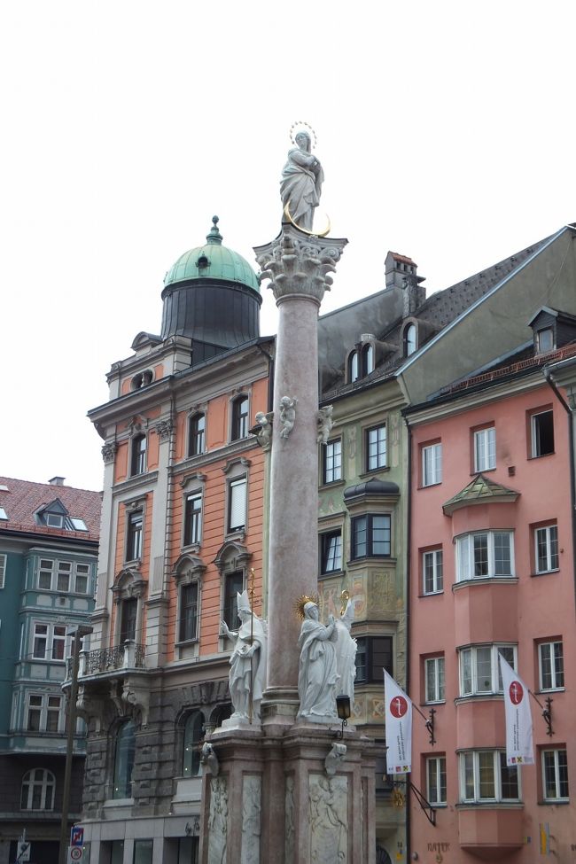 旧市街に向かって、マリアテレジア通りを進みます。<br />軽く左に折れたところからアンナ記念柱が見えます。近づいて写真を撮ろうと思ったら、凱旋門側は後姿です。前に回りこむと、ベストポジションは混雑しています。