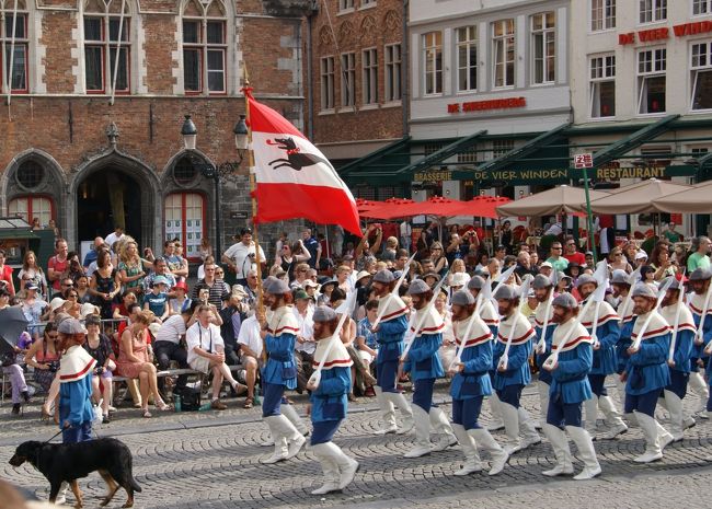 持っている旗は犬のマーク、しかも犬を連れての行進です。