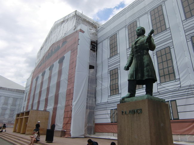 オスロ大学の前にはムンク像がある。<br /><br />大学は工事中で、建物の絵を書いたカバーをしている。<br />