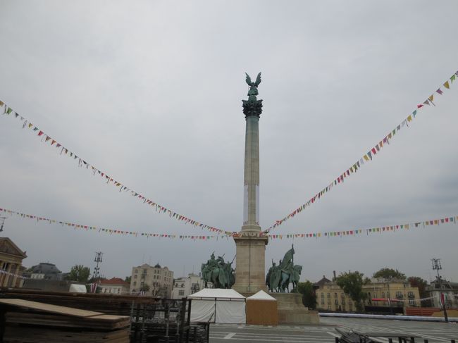 何とか英雄広場に着きました。<br />ハンガリー建国100年を記念して1896年に造られた広場だそうです。<br />中央に36メートルのポールがあり、その上に大天使ガブリエルの像が立っています。広々とした気持の良い広場です。<br />