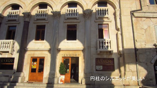 宮殿の中心であるペリスティルの前にある有名なレストラン、ルクソール。何かエジプトのような名前だが、理由が有りそう。<br />朝日が、宮殿の円柱の影をくっきりと壁面に描いている。