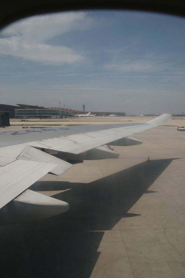 飛行機に乗ると、外の暑さから開放されるかな？と思ったんだけど、物凄く暑いんです。エアコンがついていなくて送風オンリーといった感じ。これもエコの一環ですか？でもちょっとやりすぎじゃないの？と思うくらい暑かった。乗客の殆どの人が何かしらの物で扇いで少しでも涼しくなろうとしていたし、乗務員を捕まえてはエアコンの件を聞いていた様な気がする。結局この状態はエンジンが始動してからも暫く続きました。 <br />出発間際にコンテナのローダーがオーバーヒートして故障してしまうトラブルもあったけどトラクターで引っ張ってもらってなんとか外れました。 <br /><br />