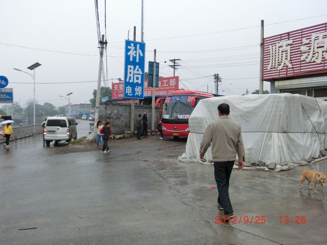 一旦高速道路から降りてタイヤ修理 <br /><br />修理と言ってもスペアータイヤと交換で<br />破裂したタイヤは廃棄処分だろう <br /><br />小雨の中、下は地道で交換も大変だ <br /><br />