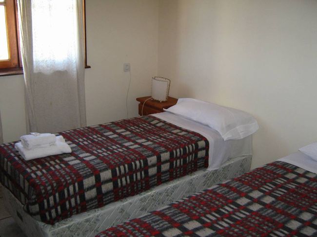 カラファテに到着し、バスターミナルから歩いて予約したユースホステルへ。写真はホステルの部屋。レストランやロビーはすてきなつくりになっていたが、トイレのドアがしまらなかったのが残念。ホステルは高台に建っているので眺めがいい。町へは埃っぽい道を１０分くらい歩いて行かなければならなかった。