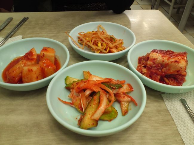 ２日目です。<br /><br />南大門に行って朝ごはん♪<br /><br />南大門を歩いていると、日本語でがんがん声をかけられます。<br /><br />「おねーさん、完全なニセモノあるよ〜！」<br />「おねーさん、ニセモノ見てって！」<br /><br />腕を引っ張られたりするので、すっかり引き美味のわたしたち。<br />さっさと食堂に入ります。<br /><br />これはつけあわせのキムチ。<br />友人Ｒは、マメモヤシをすっかり気に入りました。