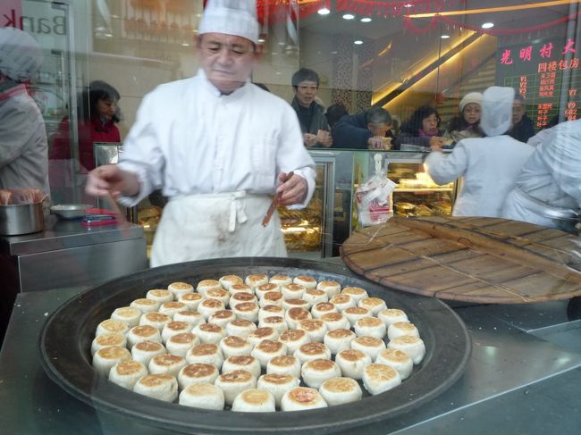 行列を見つけちゃったら並ばない訳にはいかないでしょう♪<br />店の中では肉月餅を焼いています。<br />中華風ミートパイだね！<br />寒いけど並ぶどー♪<br />