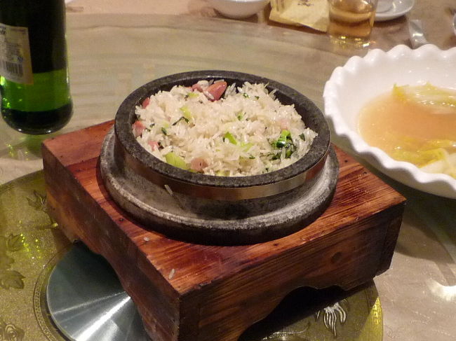 「石鍋肉菜飯」　28元（390円）　中華ハムと菜っ葉の炊き込みご飯<br />またしても石鍋かい！以前はステンレスの桶でした。<br />昨日の夜から3店舗連続で石鍋登場！<br />上海は今石鍋料理がブームらしいぞ！！<br /><br />時間が経っても温かくって、菜飯の器に石鍋は大正解だね。<br />ハムの塩気がほんのりおいしい♪<br /><br />さてお会計。<br />大人3人＆9歳児＆乳児です。<br />材料購入費430元＋レストラン支払452元＝882元（12300円）<br />一人3500円位ですね。<br />