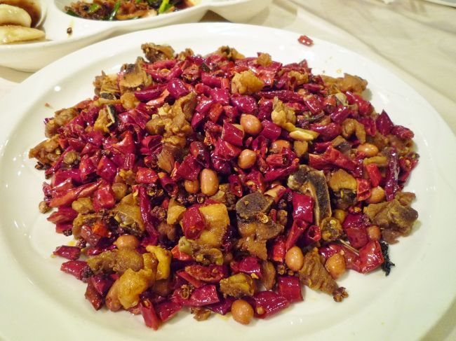 「辣子鶏」　骨付き鶏と唐辛子の唐揚げ<br />中国来たら必ず一回は頼む一品！<br />この真っ赤な唐辛子の山が目に痛い〜！<br />日本だとなかなか満足いく皿に出会えないメニューでもあります。<br /><br />カリッと揚がった鶏肉は山椒が効いててヒーハー的なさわやかな辛さ！<br />クリスピーな食感なので、ビールのお供に最高♪<br />ついついお箸がのびちゃいます〜<br />