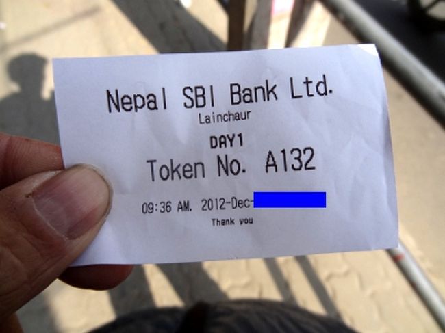 　これが、その番号の書かれた紙切れ。あるブログには、前のほうの番号は警備員や職員がゲットして、後からきた人に高値で売りつけるという話が書かれていました。しかし、私が見た感じでは少し違います。一番に並んだ人は、やはりA1の番号を得ています。どうも、警備員はなじみの旅行代理店から連絡を受け、適当に引き出しておいた番号を渡しているようです。そうすれば、代理店のスタッフは、他の申請者のように何時間も待たずにすみます。ちらっと見た感じでは、250ルピー(250円)ほど渡してたようです。<br /><br />　ここまで言及してませんが、インドビザは、日本同様、旅行代理店に代行取得してもらうこともできます。自分でやるのは、オンライン申請と写真の用意だけ。代理店の職員が代わりに並んで申請してくれます。正確な相場は知りませんが、ある店だとビザ代込みで4500(4500円)くらい。経費を除けば約3000円のサービス料ということになります。高いような、安いような..。でも、パスポートを長期間預けておくのは、あまり気持ちのいいものではありません。