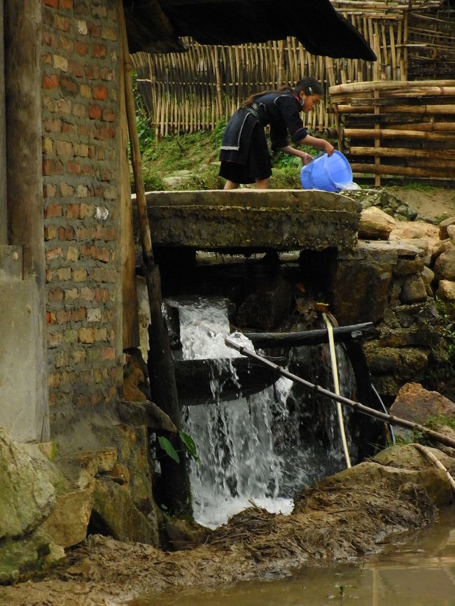 小水路で水車を回して脱穀などをしている。<br /><br />少女も何かお手伝い。