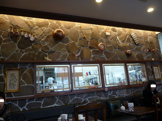 カフェコーナーの向こうはオープンキッチンになっています。<br />真剣にケーキ作りをするスタッフの様子も見えます。<br /><br />壁には、インテリア代わりに調理器具が掛けられています。