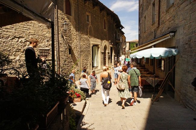 2012年 8月 12日。<br /><br />午前中は、世界遺産 サンマリノ共和国で、中世の砦を回ってみました。<br /><br />市街に戻ったら、まずは、ツーリスト・オフィスに行って、パスポートに観光ビザのスタンプを押してもらいました。有料 （? 5） だけど、こういう小さな国はあまり来る機会もないと思いますし。<br /><br />お昼近くなって、市街地に観光客の人数がいっきに増えてきました。<br /><br />みんな午前中のバスでやってきて、ランチを挟んだ数時間滞在し、帰っていくんですね、きっと。<br /><br /><br /><br />