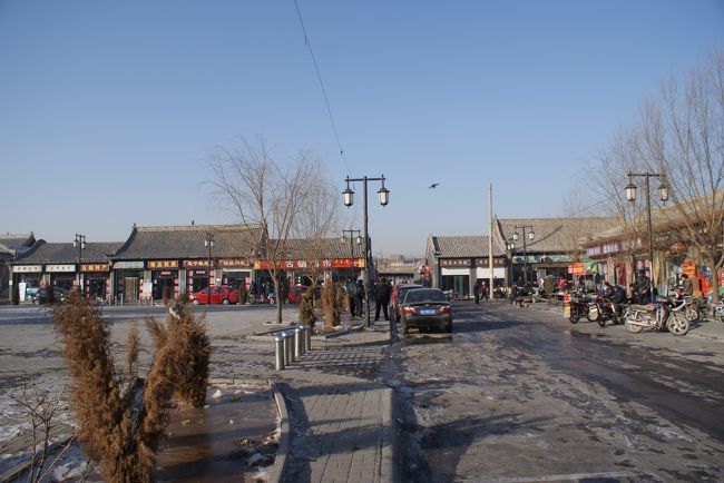 中心街にバスは着きました。<br />暖泉のメインストリートを振り返ります。<br />お目当ては小さいながらもかつて城壁に囲まれていた村々<br />このメインストリートを挟んで徒歩圏内に「北官堡」（正面の路地を入った奥）、「西古堡」「中小堡」が点在してます。<br />まずは暖泉の中心街の先にある、徒歩10分程度の西古堡(シーコンボ)をめざします。<br />５分ほど歩いてゆくと「中小堡」の入り口が左にありますが、<br />後回しにして更に10分ほど…<br />