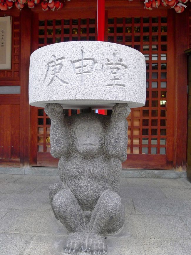 「庚申堂」と書かれた石を頭上に掲げたおさるさん。