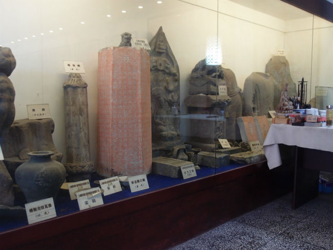 出土品の展示です。奥の菩薩身像は唐代等のものです。赤色の多宝寺経（清代）下にある折辺散口碗や、横にある寒林碑も唐代のものです。これらより、大慈寺が少なくとも唐代から存続していたことが分かります。