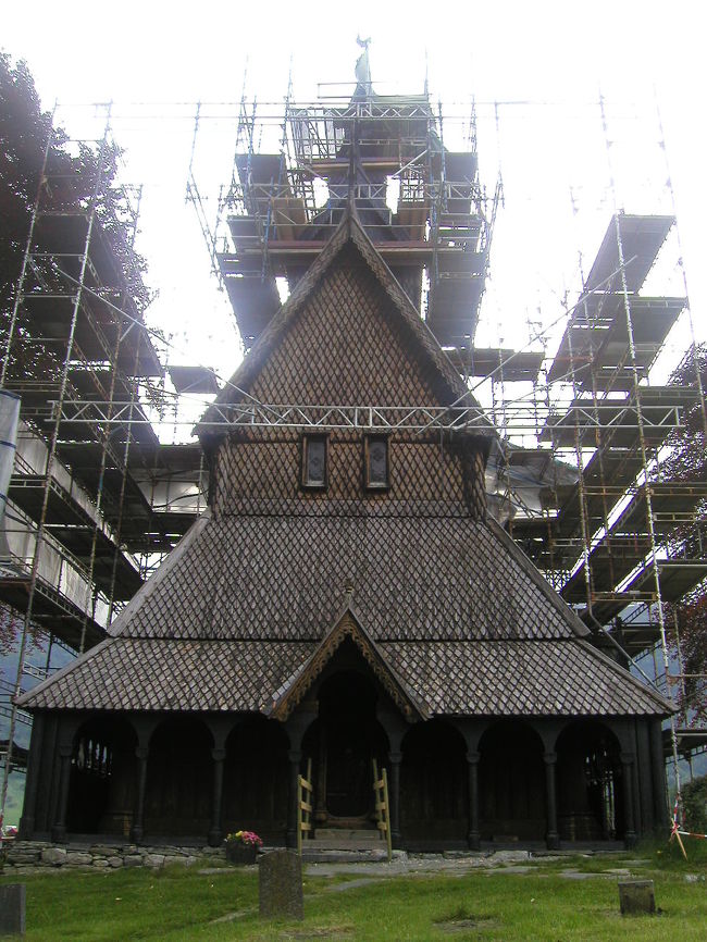 Hopperstad Stavechurch<br /><br />残念ながら教会は修復工事中で内部を見ることはできなかった。<br /><br />この教会の起源は伝説にまでさかのぼるが、ステーブ教会の中では最も古いものの一つで１１４０年頃のものと考えられている。床下から発見された彫刻などは１１世紀に古い教会を立て替えたものであることを示している。建設後７００年ほど後には使われなくなり荒れ果てていた。<br />ノルウエーの歴史遺産保存協会が１８８０年に買い取り、それを建築家 A. Blix の努力で最盛期の原型に近い形に復元させた。隣接するHobe石造教会と共にその復元は彼のライフワークであった。<br />